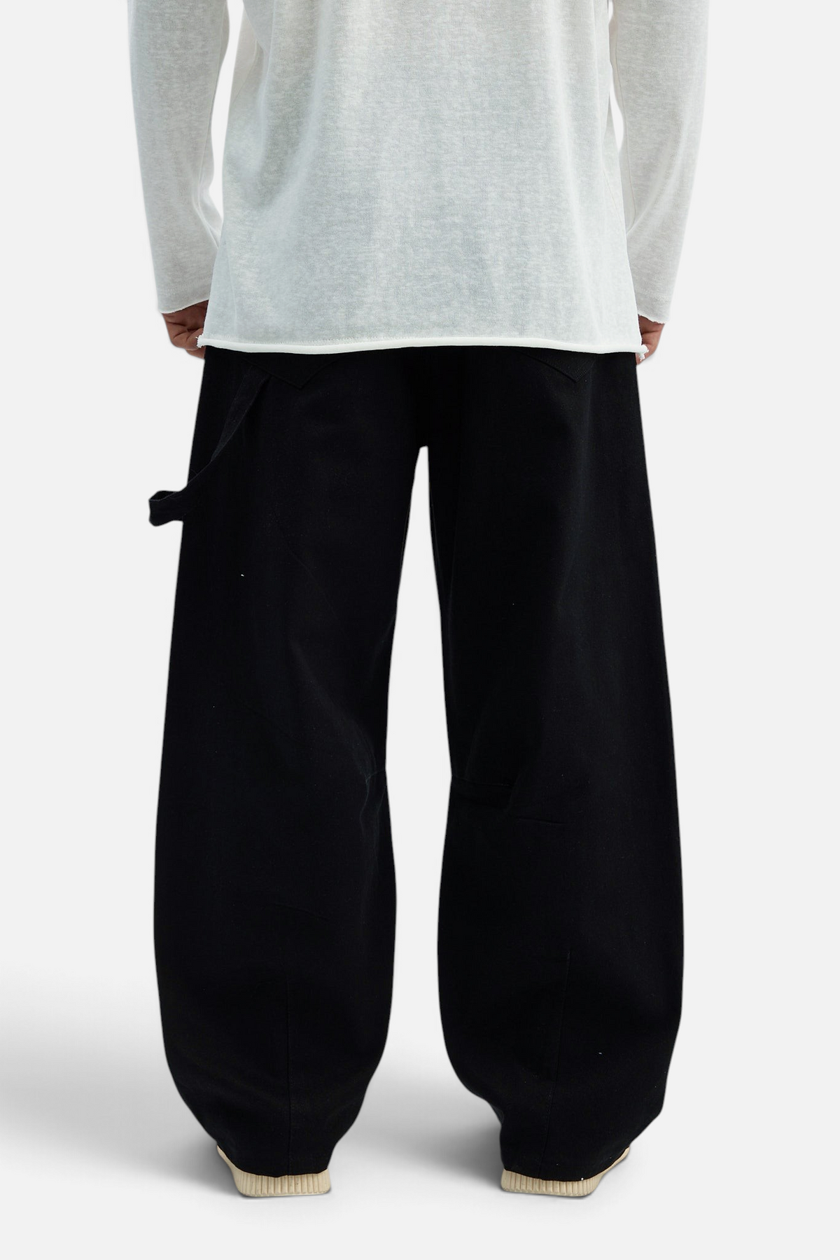Mainstreamonline black drill pants with a loose, wide-leg fit worn by a model in a white long-sleeve shirt