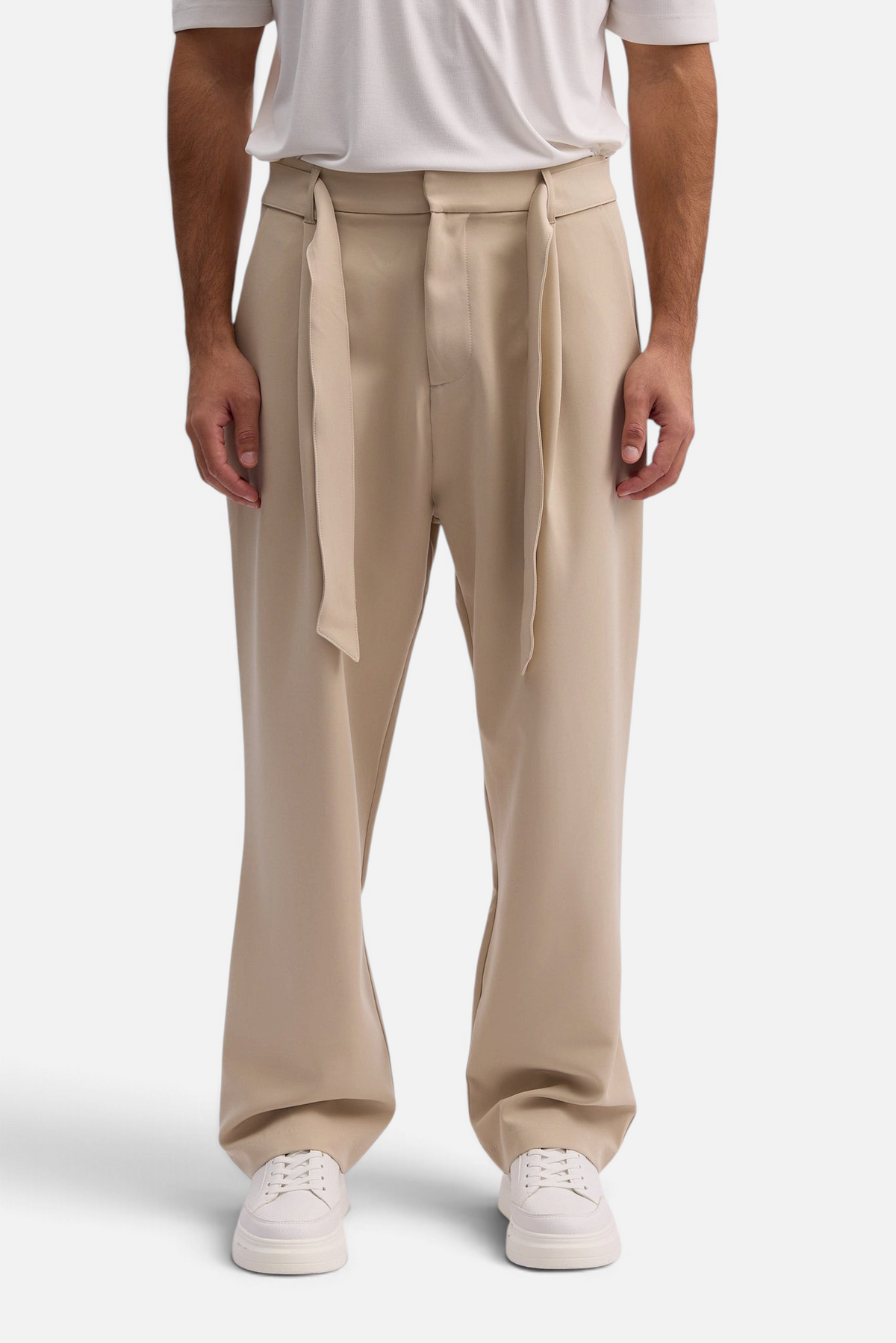 Mainstreamonline Torino wide-leg beige trousers with a tie-waist detail worn by a man with white sneakers