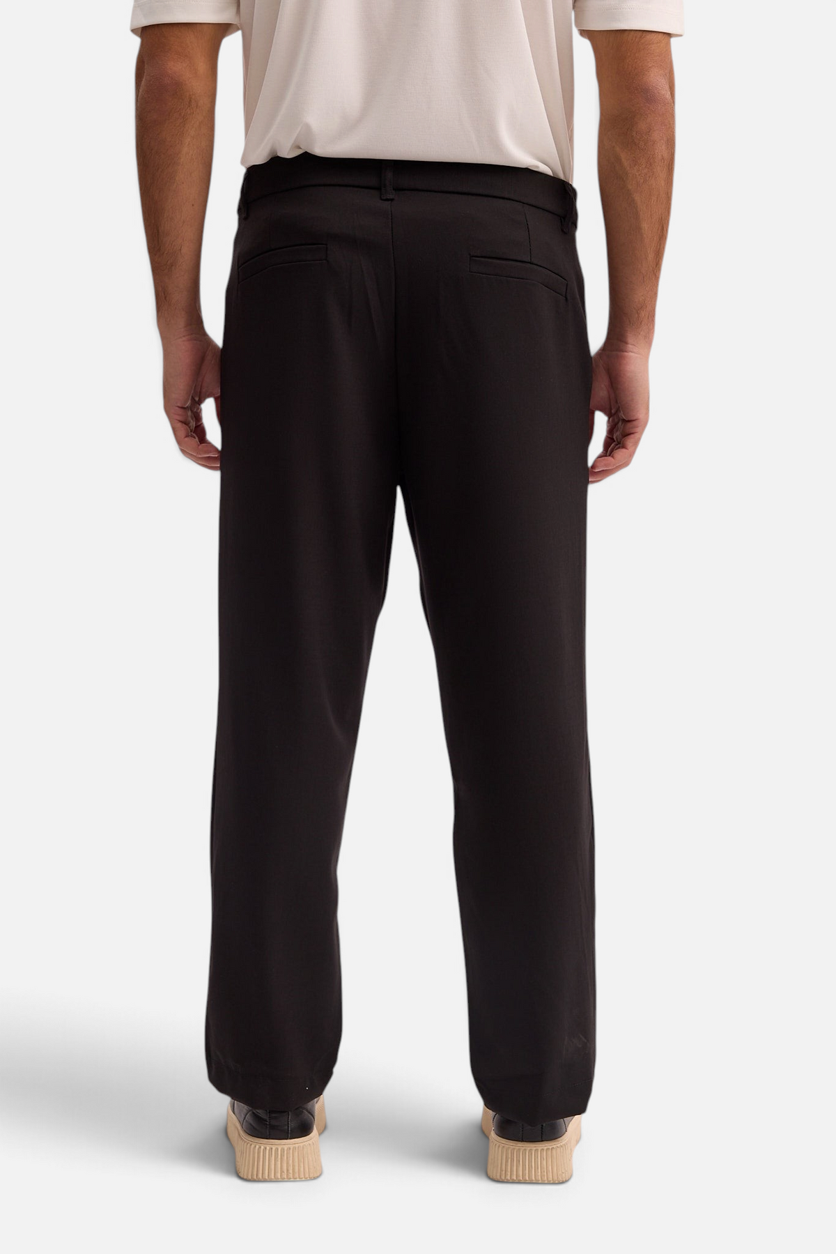 Back view of Mainstreamonline Max Pants in black with a relaxed, moderate oversized fit on a male model
