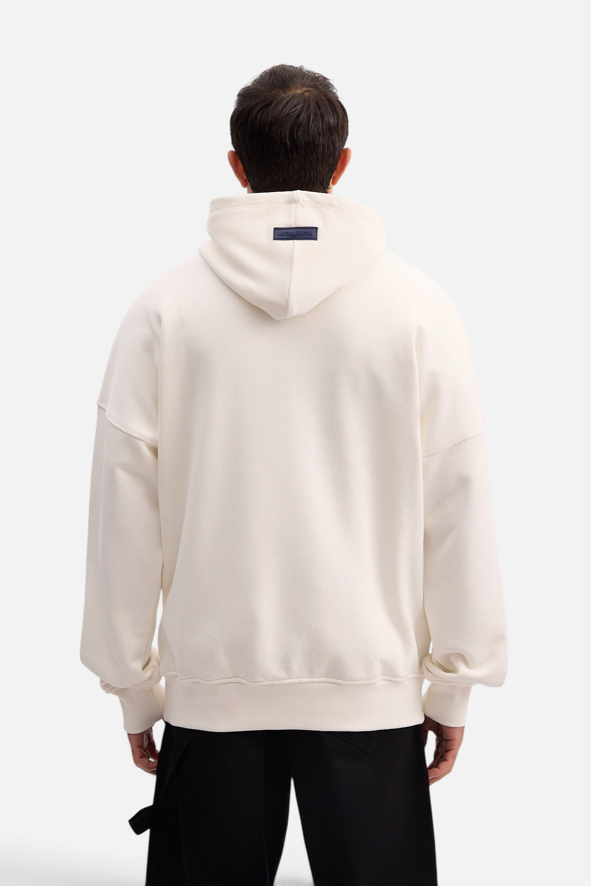 Mainstreamonline Social Club oversized cream hoodie with a relaxed fit and back logo patch, worn by a man