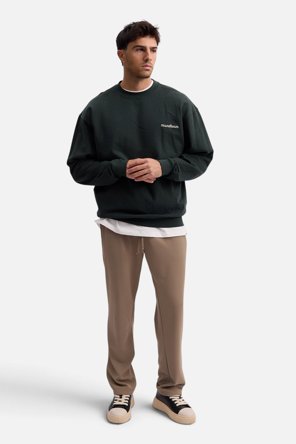Mainstreamonline Sol casual pants in beige with a straight loose fit, elastic waist, and drawstring, worn by a man.