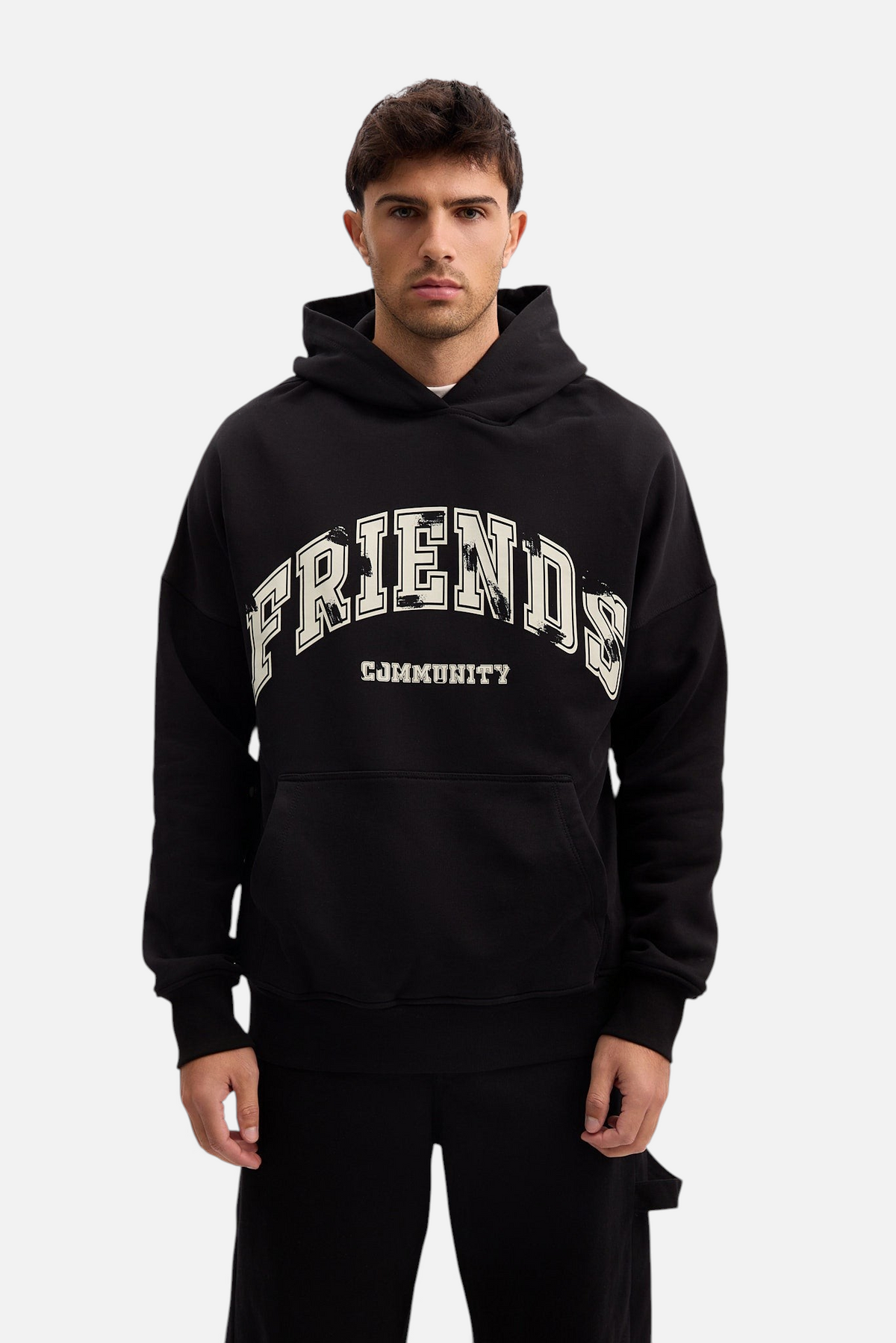 Mainstreamonline black oversized hoodie with Friends Community graphic print worn by a male model