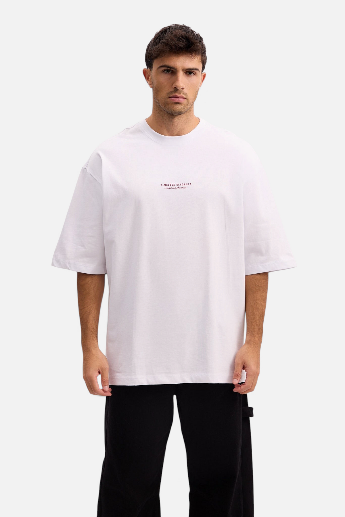 Mainstreamonline white oversized t-shirt with small chest text print worn by a male model