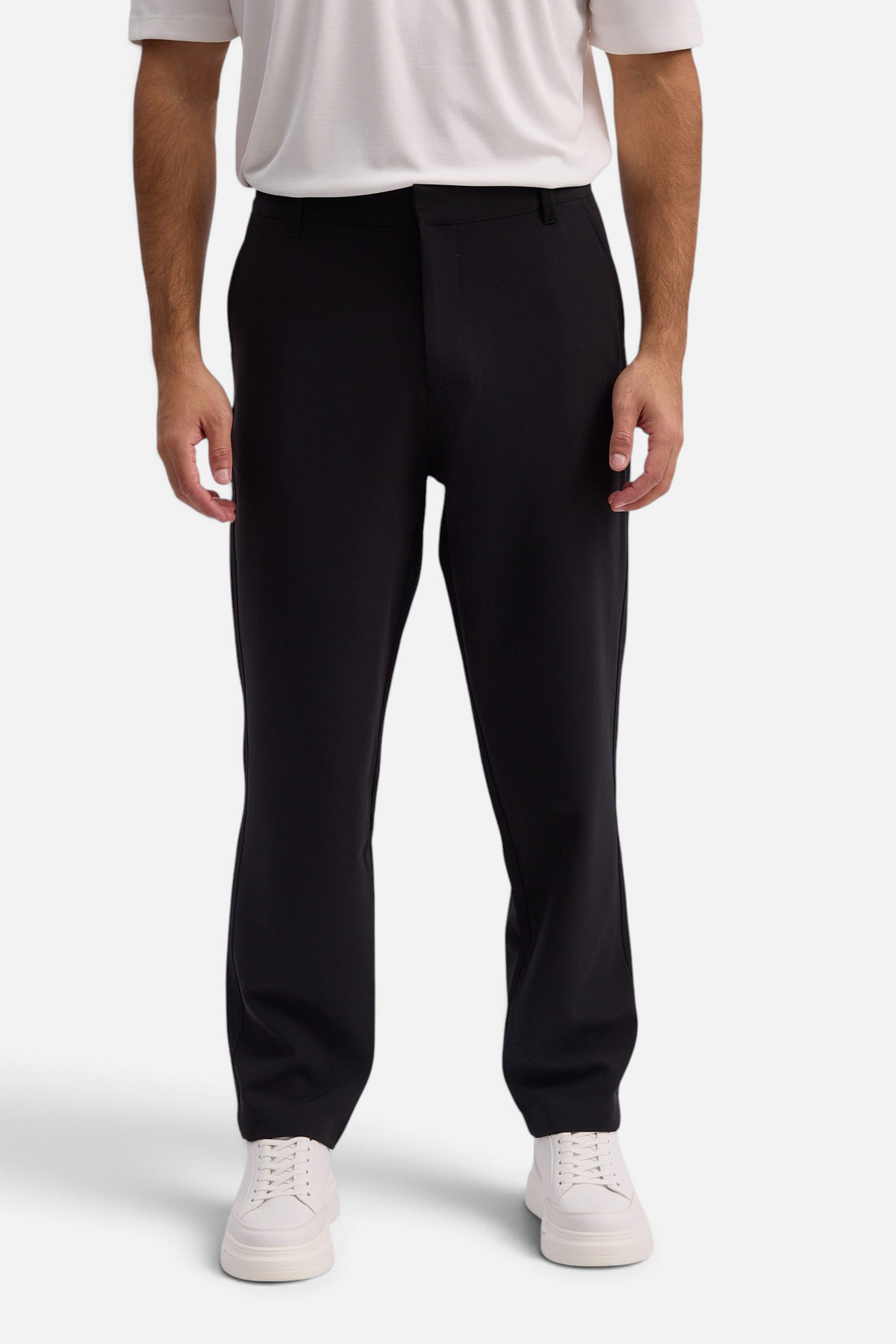 Mainstreamonline Santo Pants in black with a relaxed wide-leg fit worn by a model with white sneakers