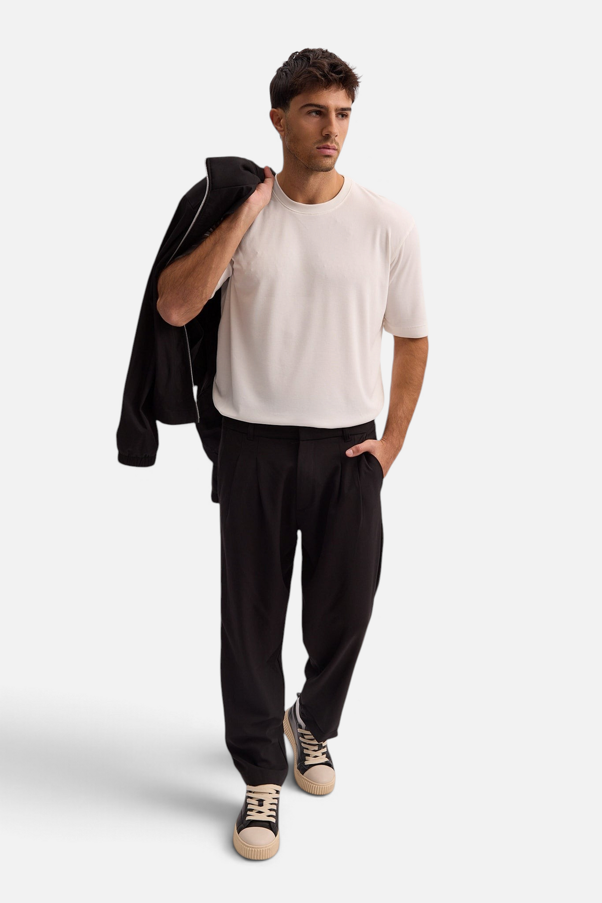 Mainstreamonline Max pants in black with a relaxed, moderate oversized fit worn by a man with a white t-shirt