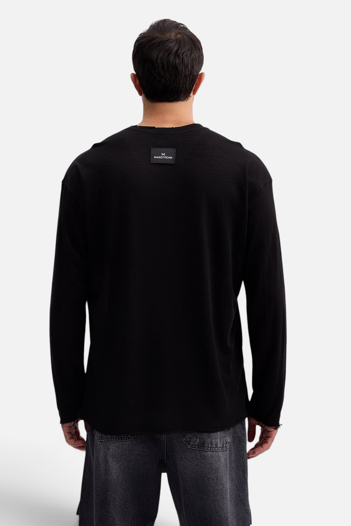 Mainstreamonline black long sleeve linen blend oversized t-shirt with back logo patch worn by a man