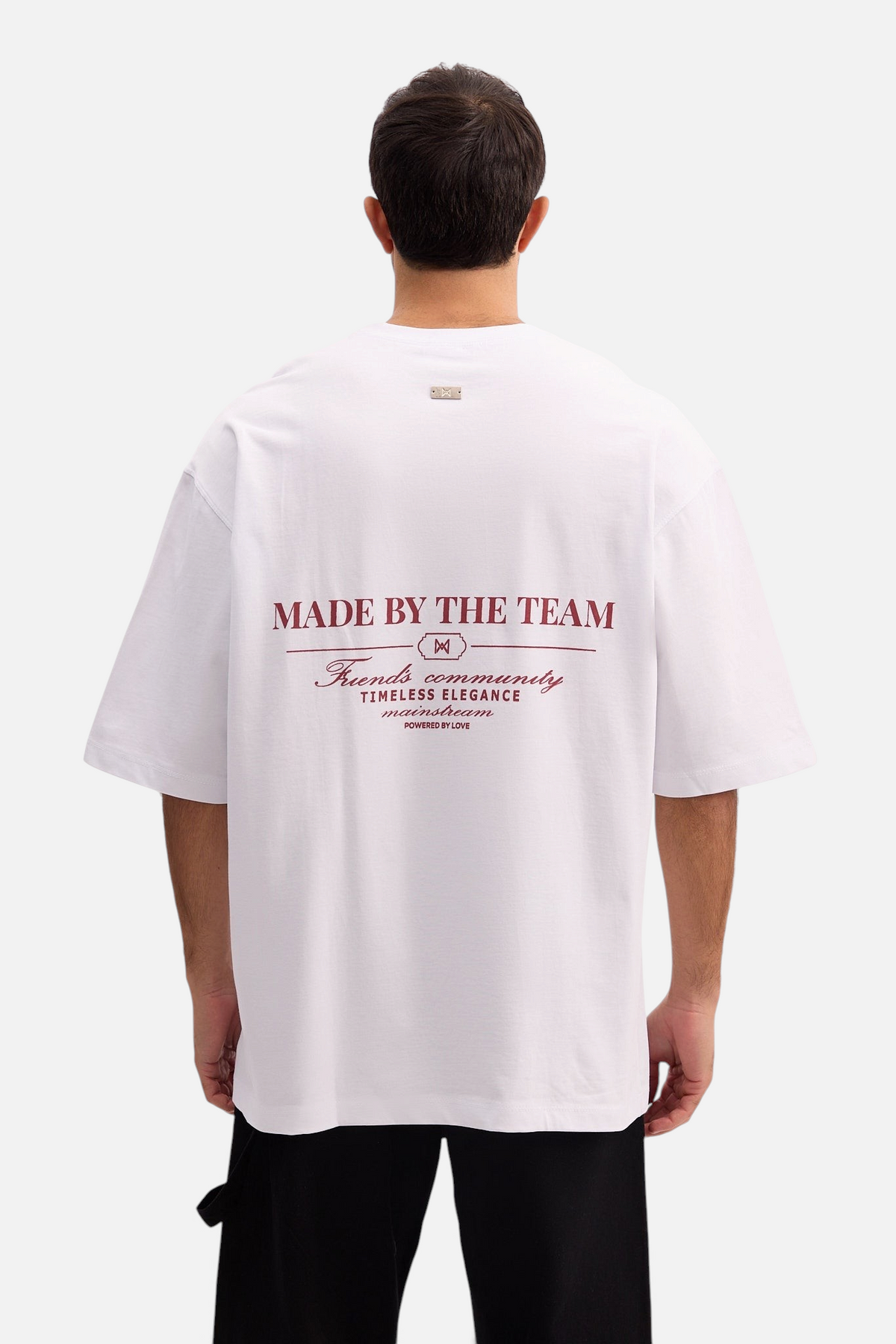 Mainstreamonline white oversized t-shirt with back graphic print featuring Made By The Team text on a male model