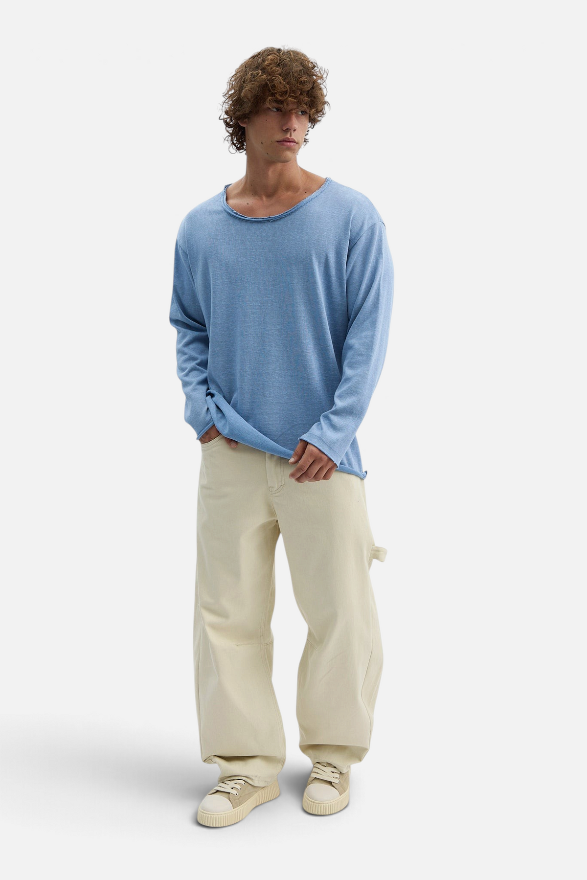 Mainstreamonline light blue long sleeve oversized t-shirt with raw edge neckline worn by a man with curly hair