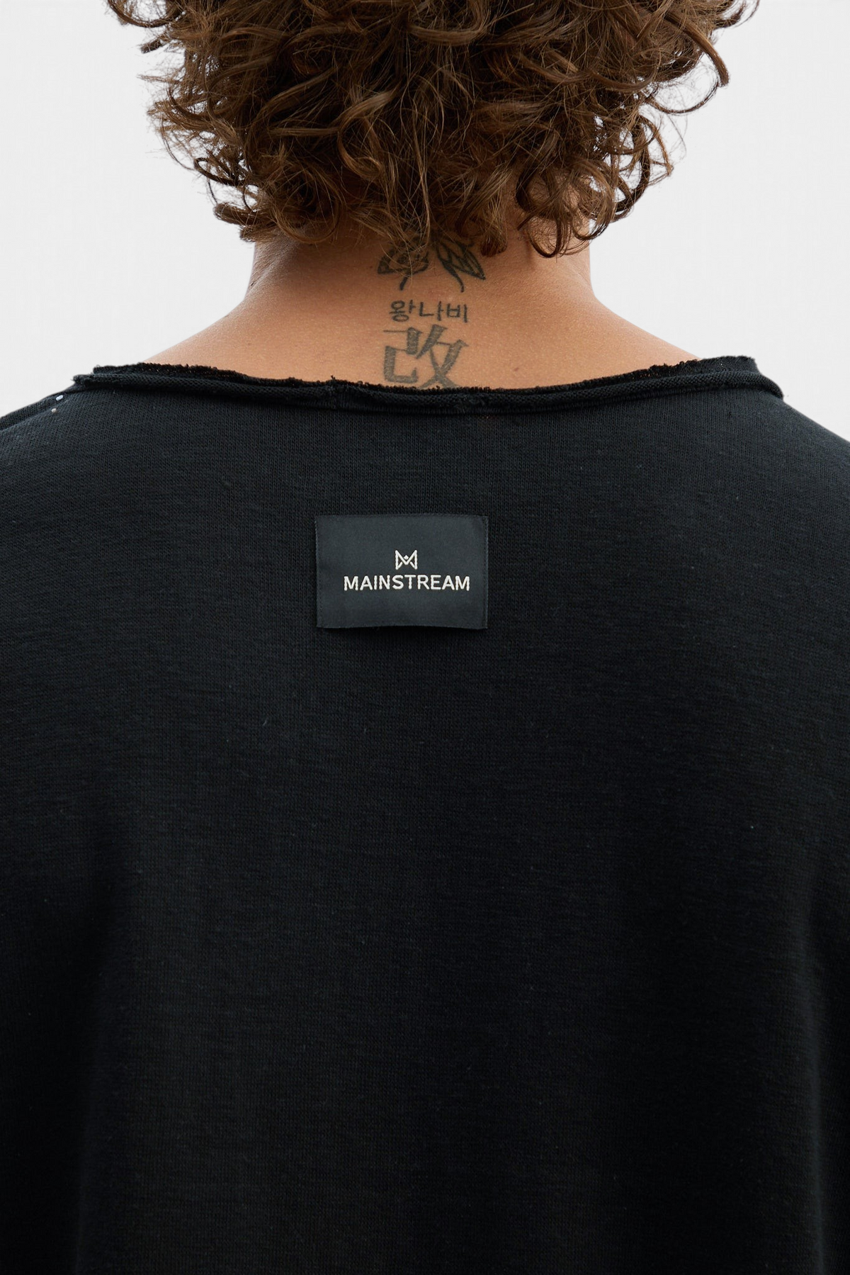 Mainstreamonline black long sleeve oversized t-shirt with raw edge neckline and brand label on the back