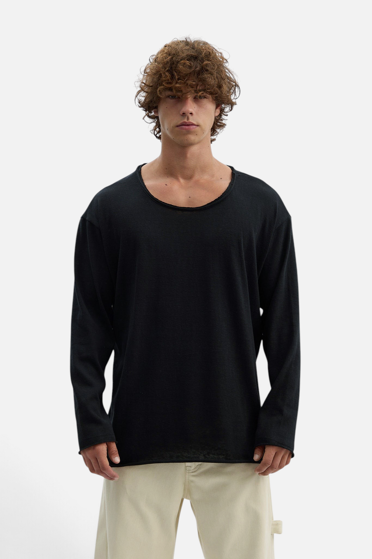 Mainstreamonline black long sleeve oversized Bali t-shirt with a raw edge scoop neckline worn by a male model