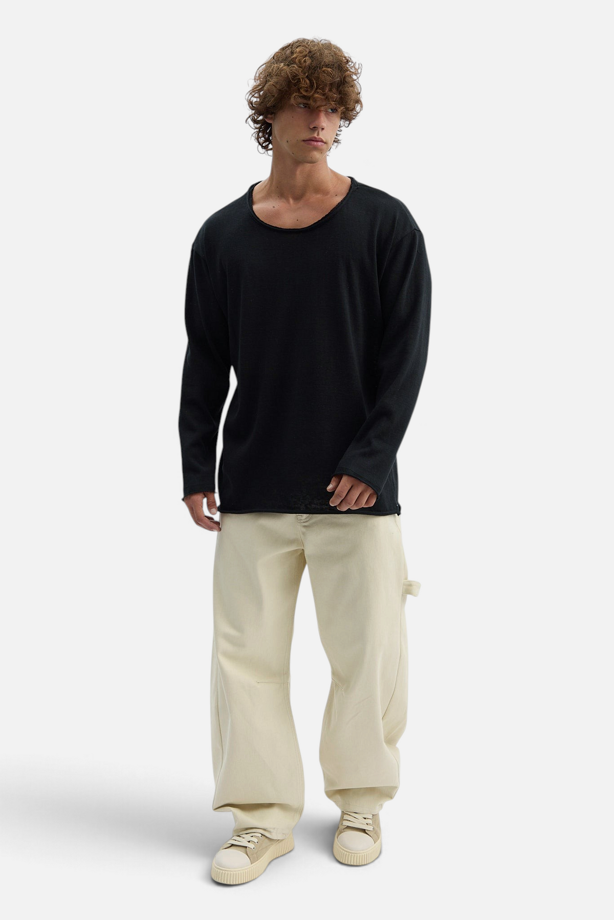 Mainstreamonline black long sleeve oversized t-shirt with a relaxed fit worn by a male model with beige trousers