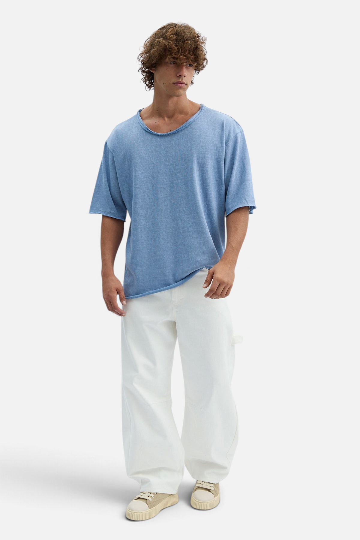 Mainstreamonline white loose-fit drill pants worn by a model with a blue t-shirt, featuring a relaxed wide-leg cut.