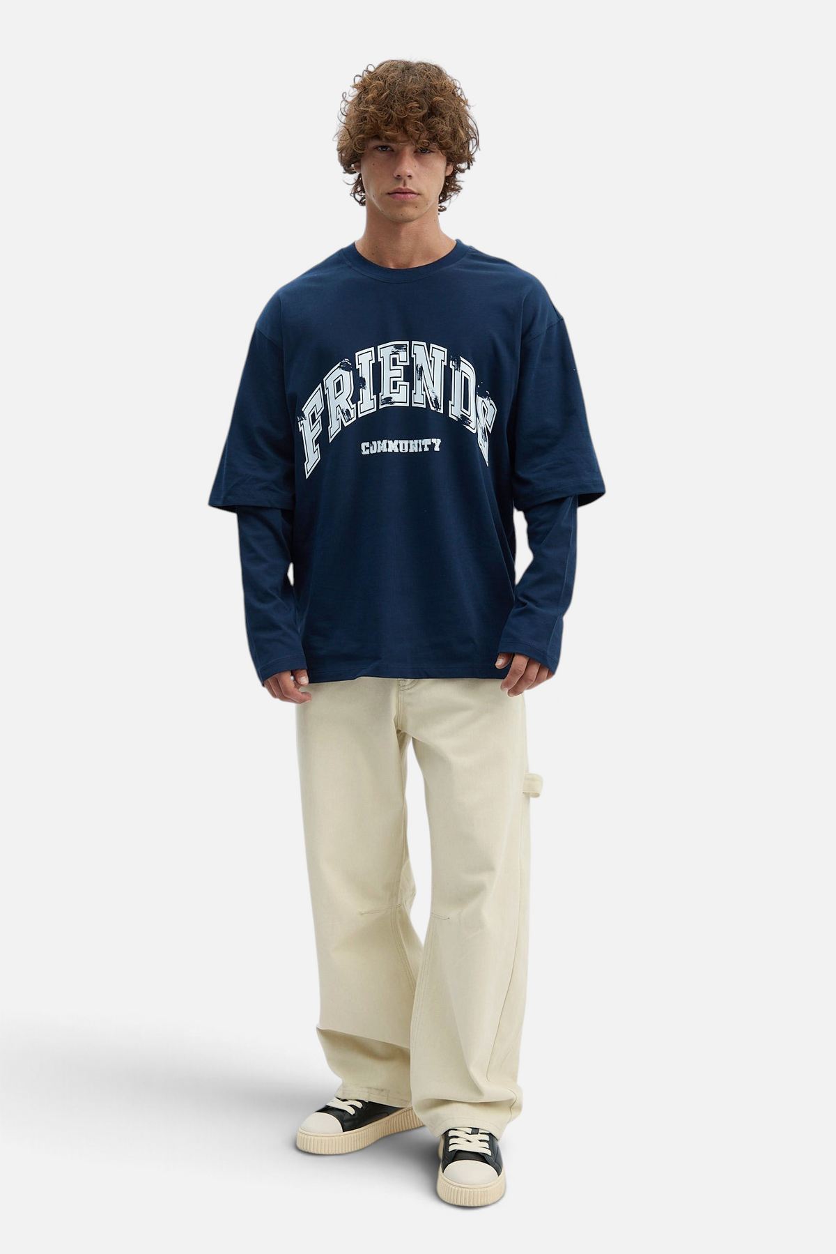 Mainstreamonline navy blue oversized long sleeve t-shirt with white Friends Community graphic print on a male model