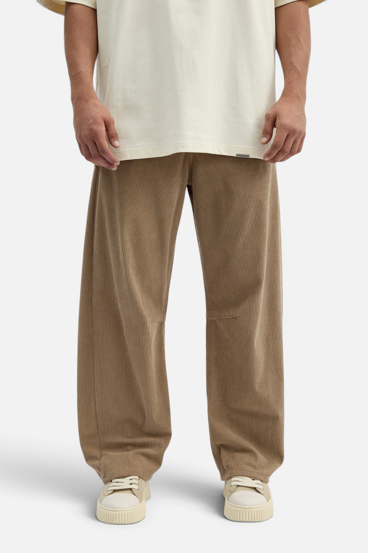 Mainstreamonline beige corduroy baggy pants with a loose, relaxed fit worn by a model in a studio setting.