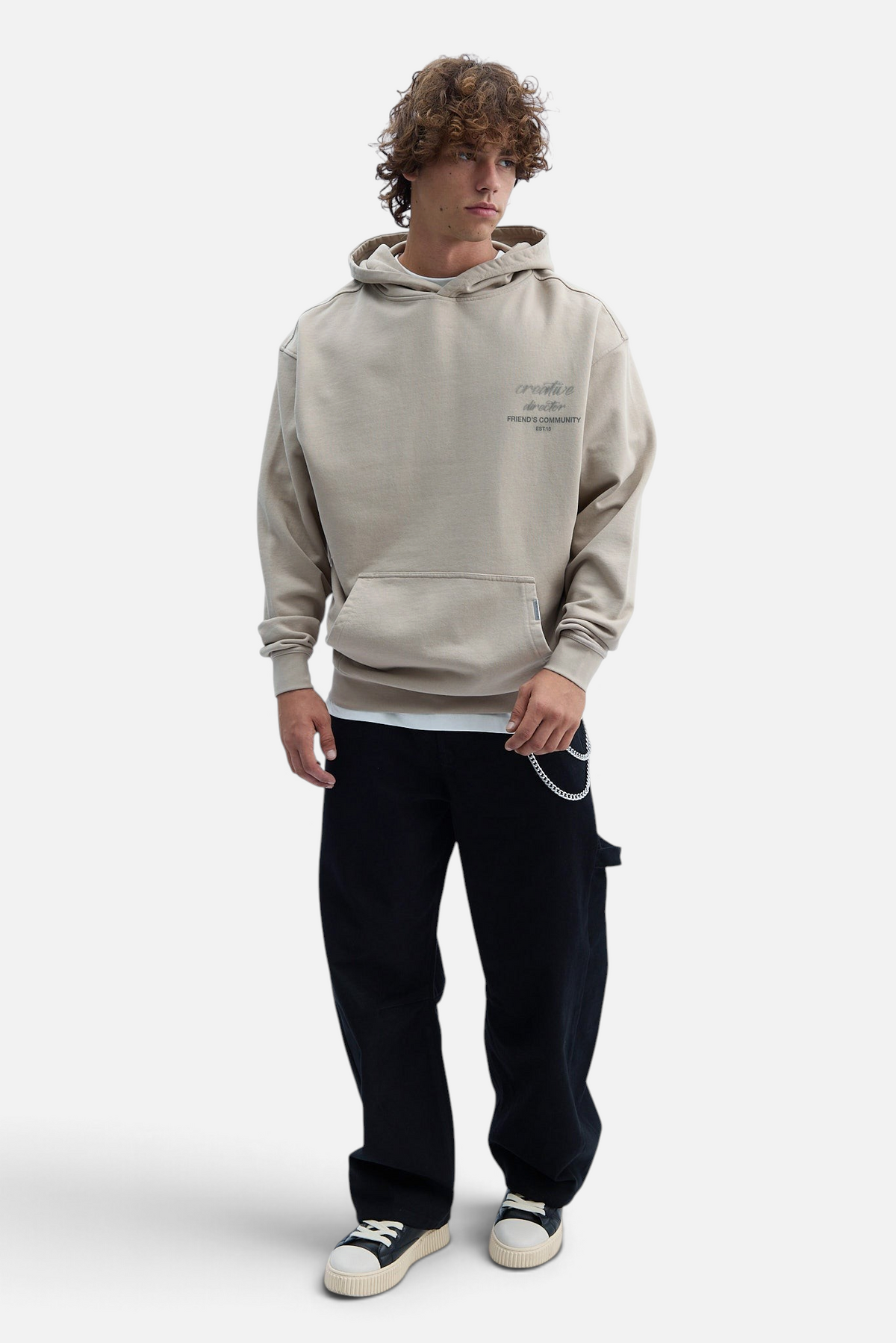 Mainstreamonline Luminous oversized beige hoodie with front pocket worn by a male model with black pants