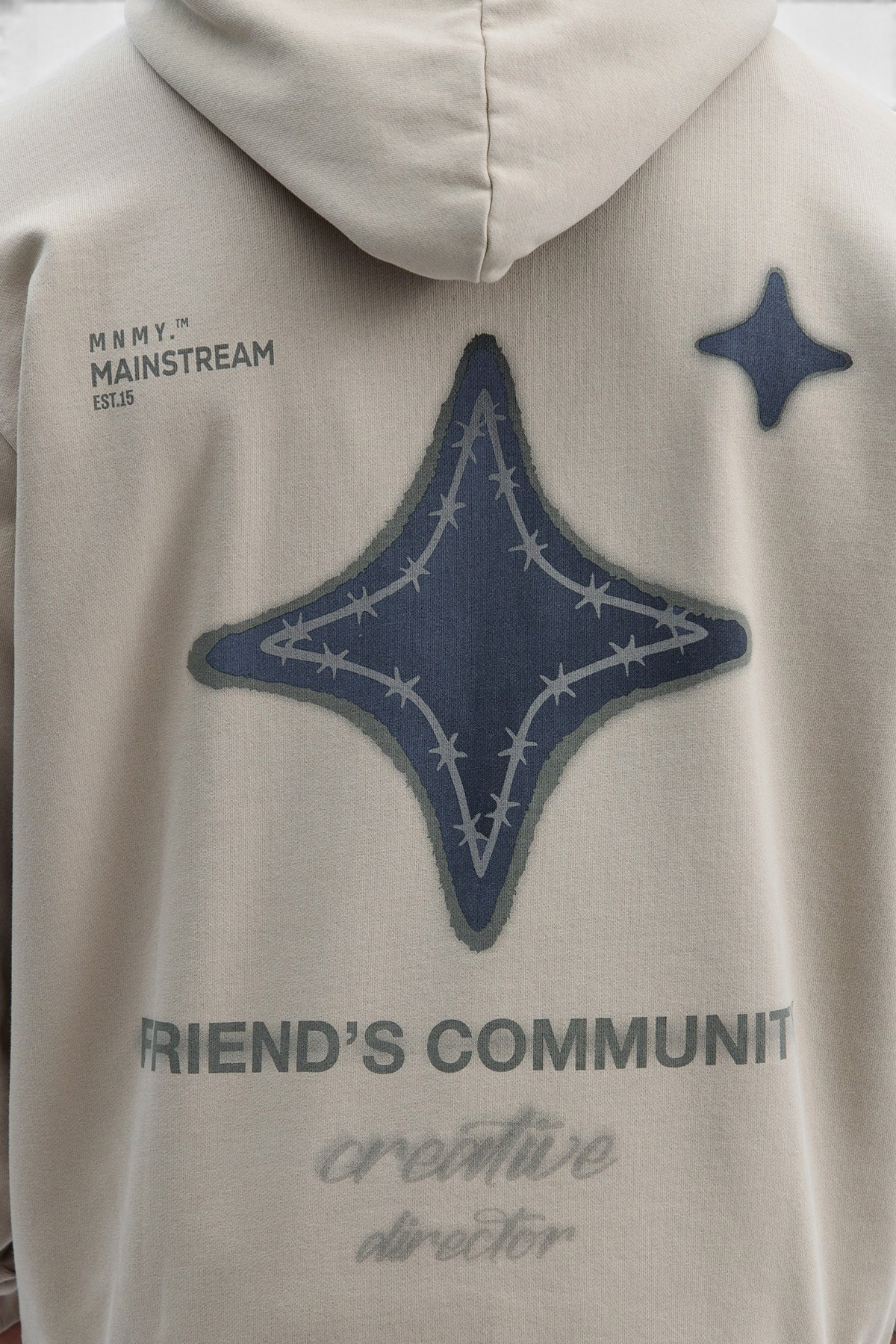 Mainstreamonline oversized beige hoodie with dark star graphic, barbed wire detail, and text on the back