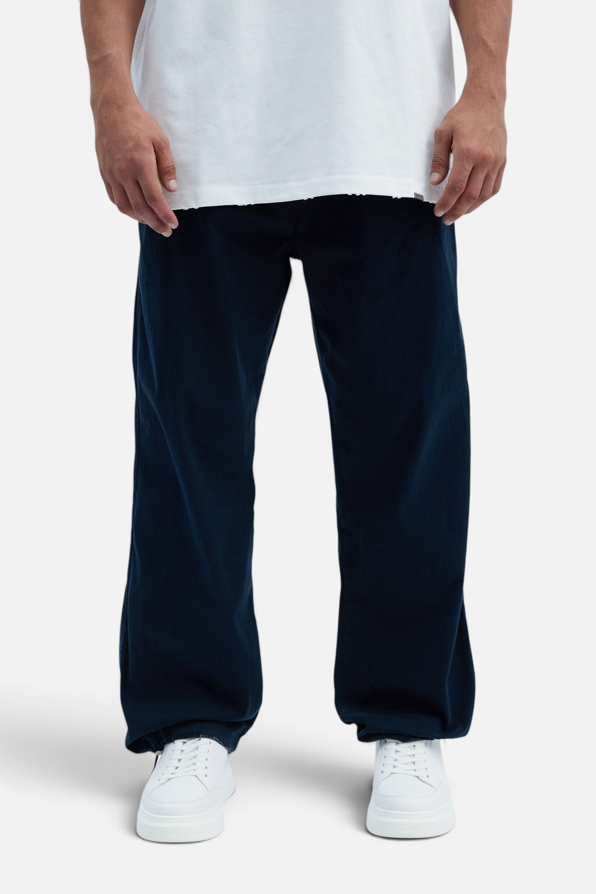 Mainstreamonline baggy jeans in dark navy blue with a loose, relaxed fit worn with a white t-shirt and sneakers