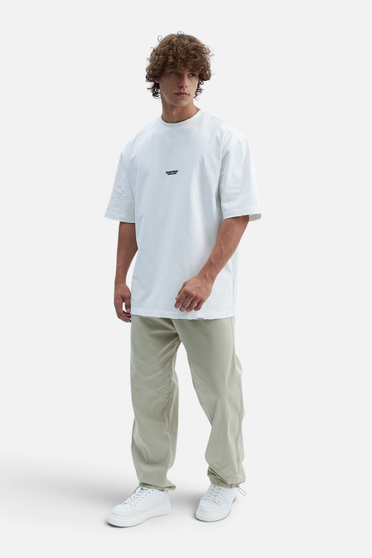 Mainstreamonline baggy jeans in light beige with a loose, relaxed fit worn by a model with a white t-shirt