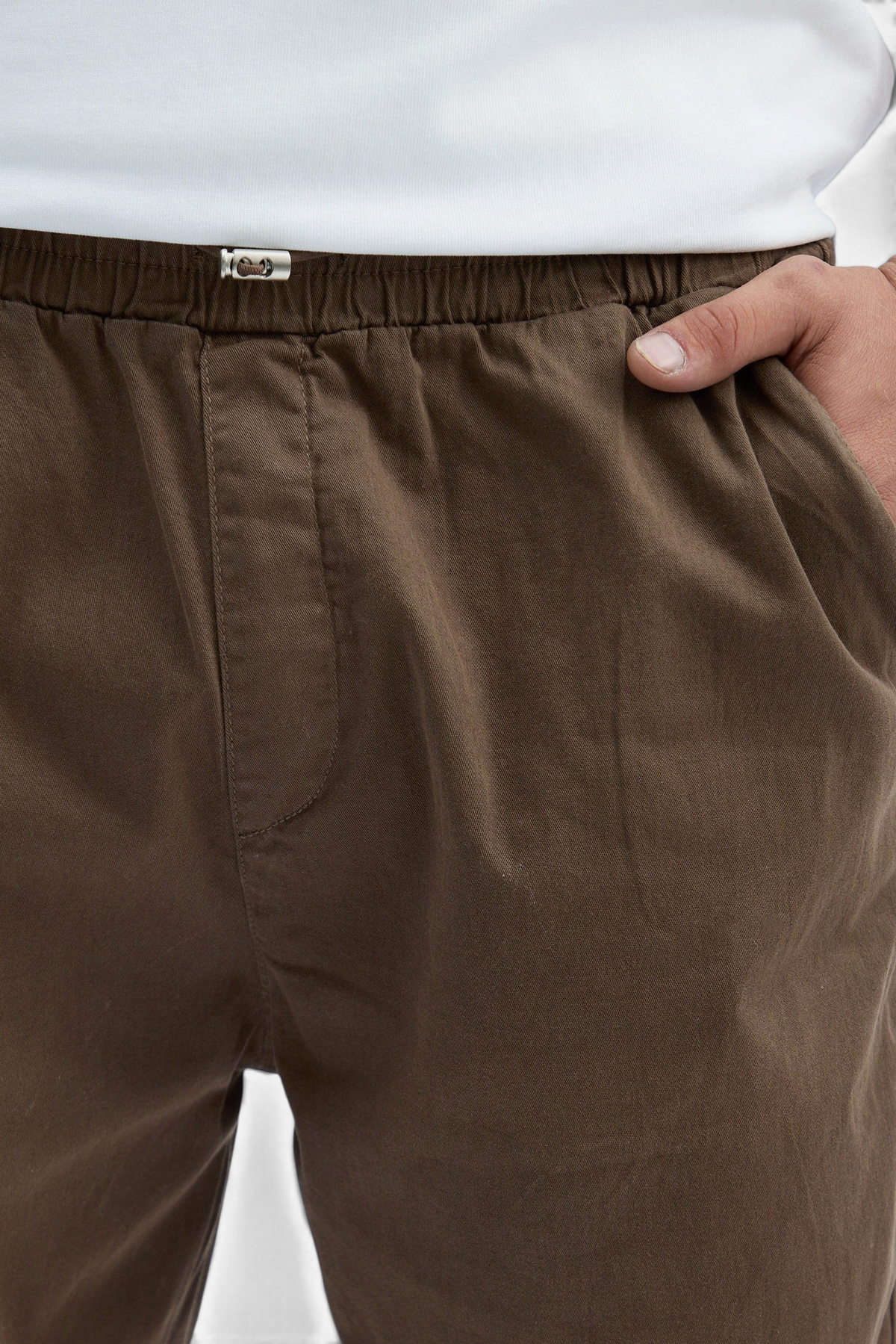 Mainstreamonline brown baggy jeans featuring an elasticated waistband and a relaxed, loose-fit design.