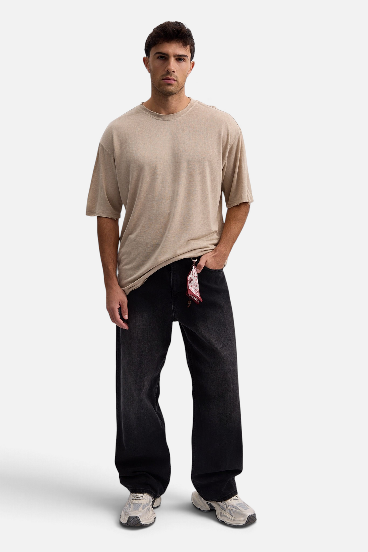 Mainstreamonline baggy skater jeans in washed black denim worn by a male model with a beige t-shirt