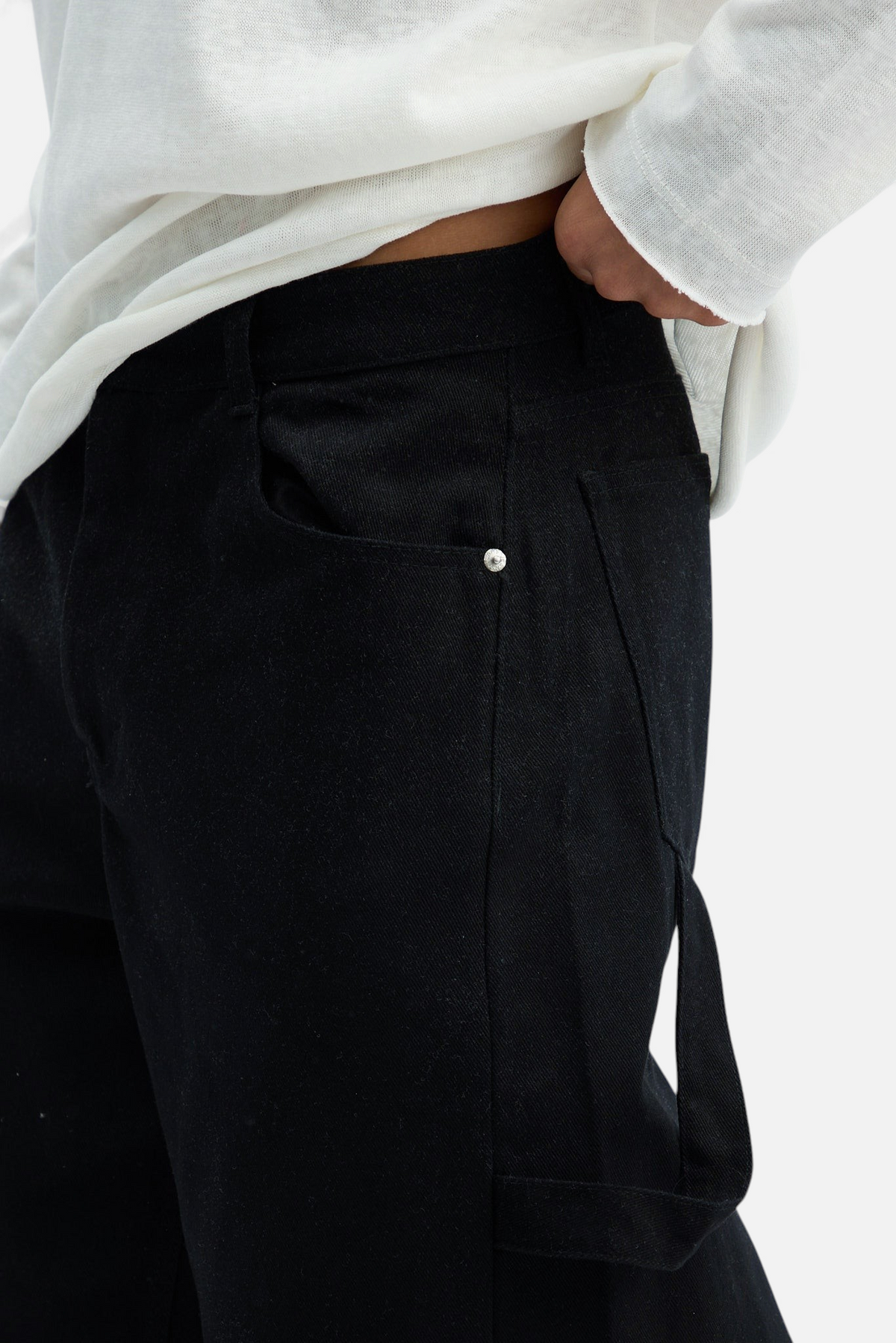 Mainstreamonline black drill pants with a loose, relaxed fit and metal rivet detail on the pocket.