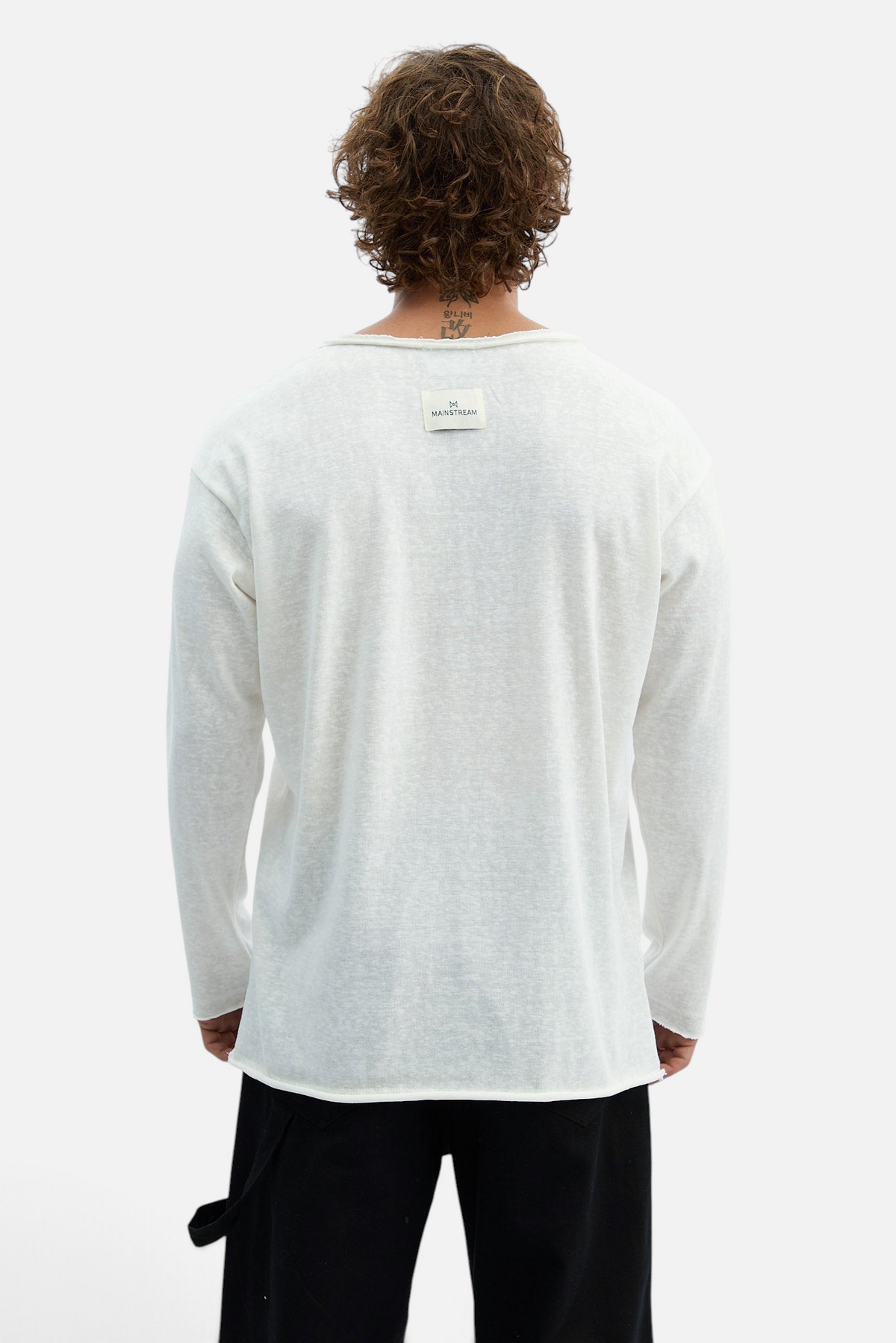 Mainstreamonline long sleeve white oversized t-shirt with raw hem and branded neck label, back view on a model