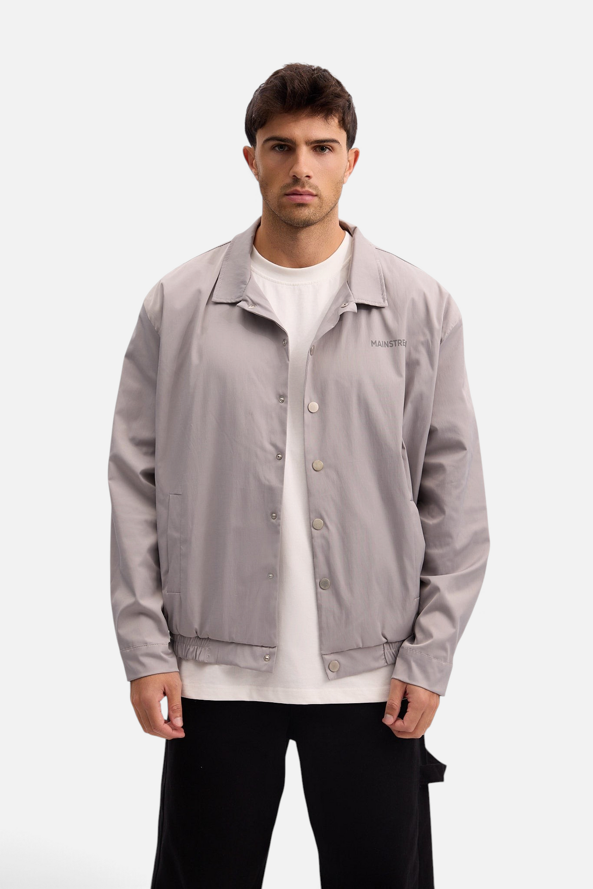 Mainstreamonline grey nylon jacket with a classic straight fit, collar, and snap button closure worn by a model