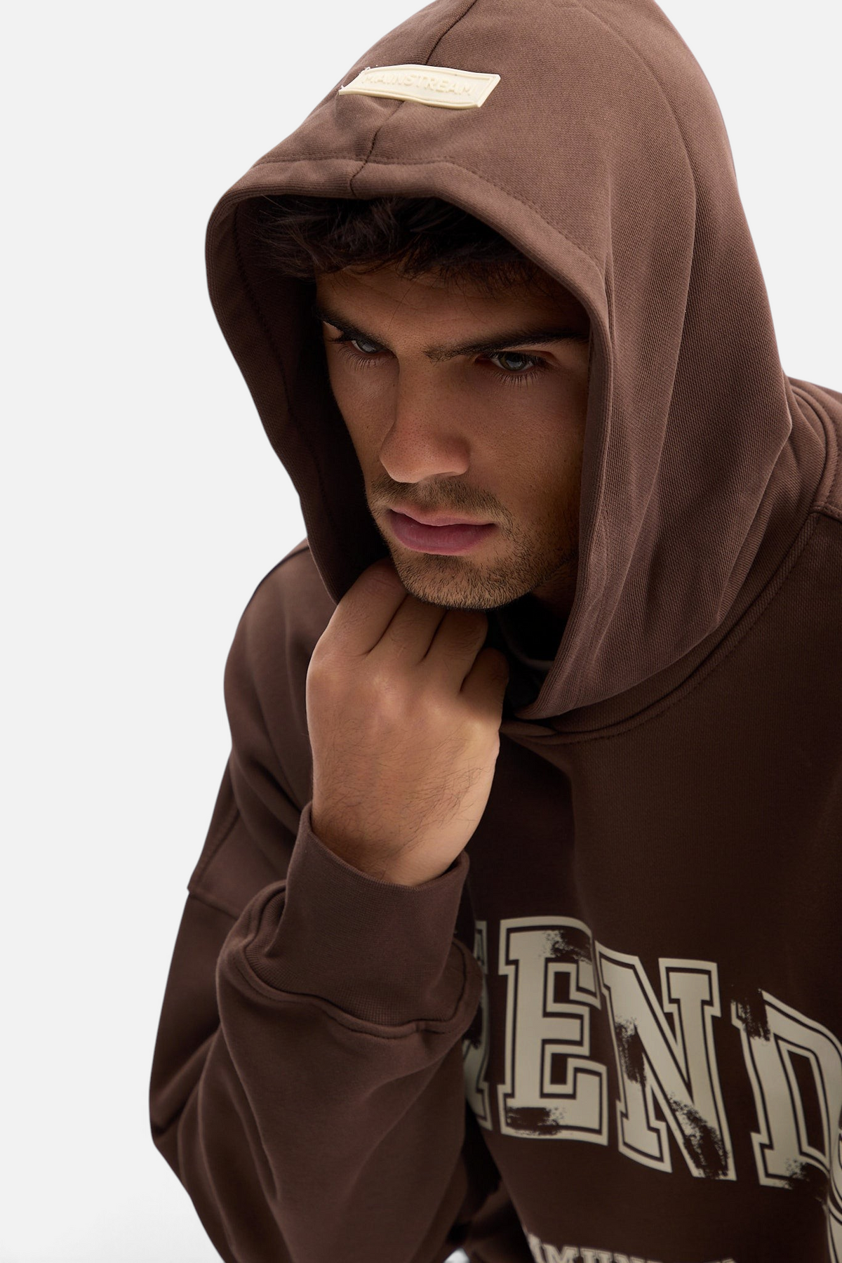 Mainstreamonline brown oversized hoodie with a relaxed fit and graphic print worn by a male model