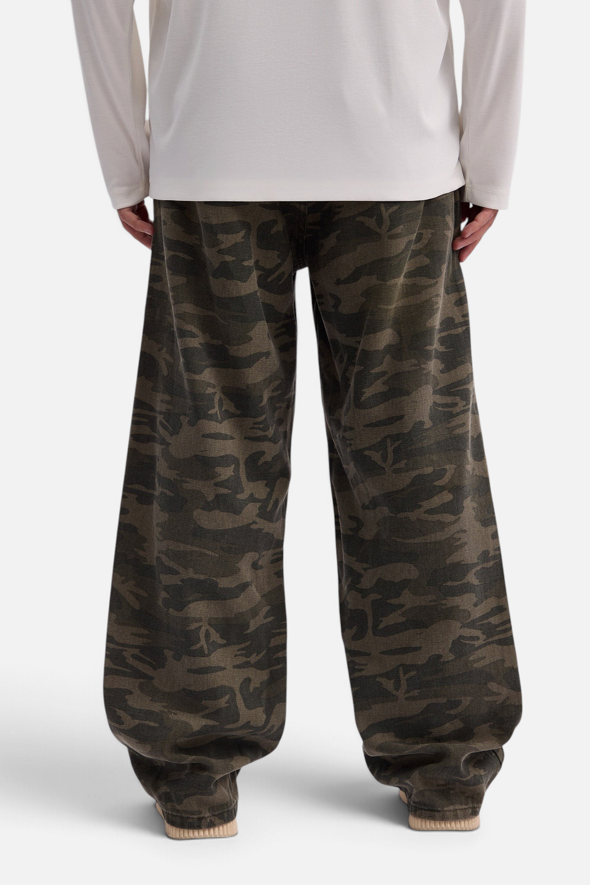 Mainstreamonline baggy army jeans in camouflage print with a loose, wide-leg fit worn by a person from behind.