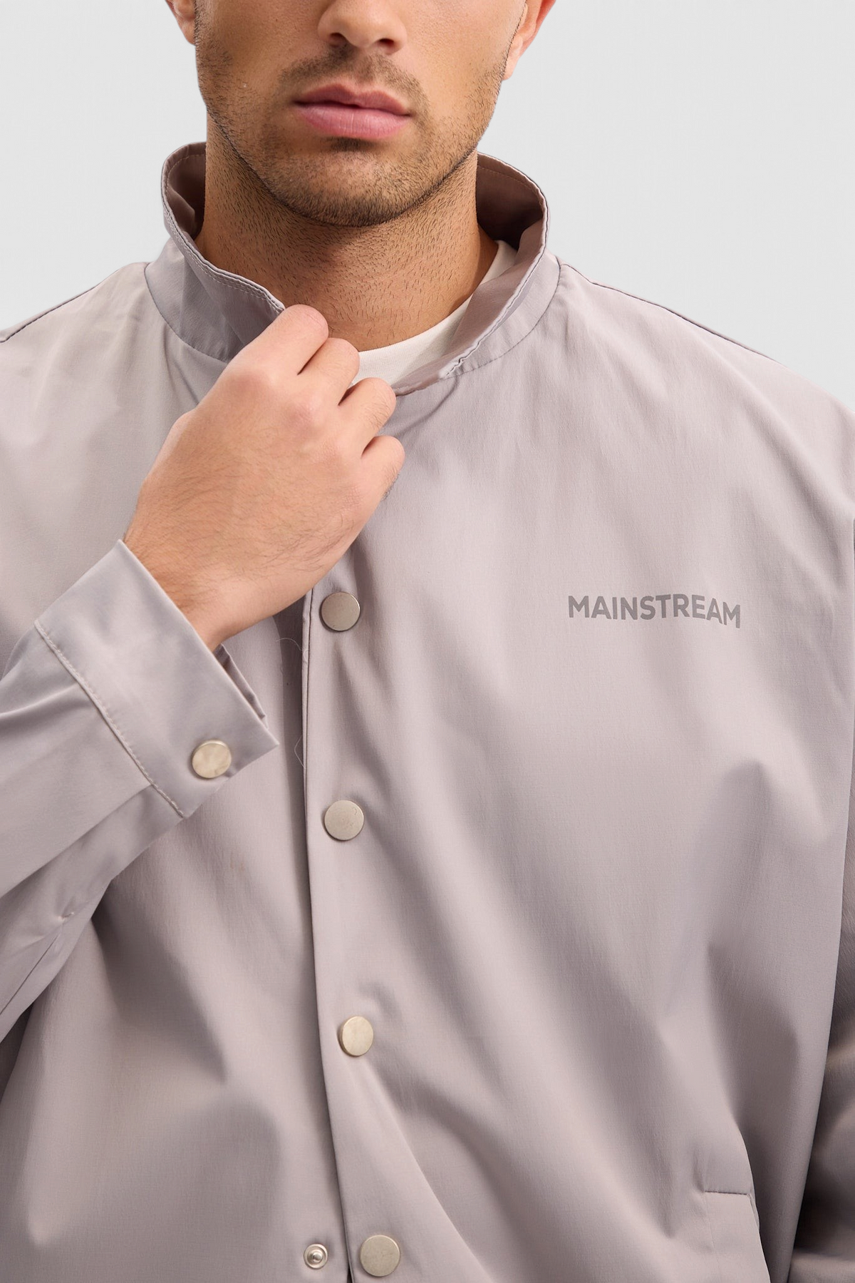 Mainstreamonline light grey nylon jacket with a classic straight fit, snap button closure, and high collar