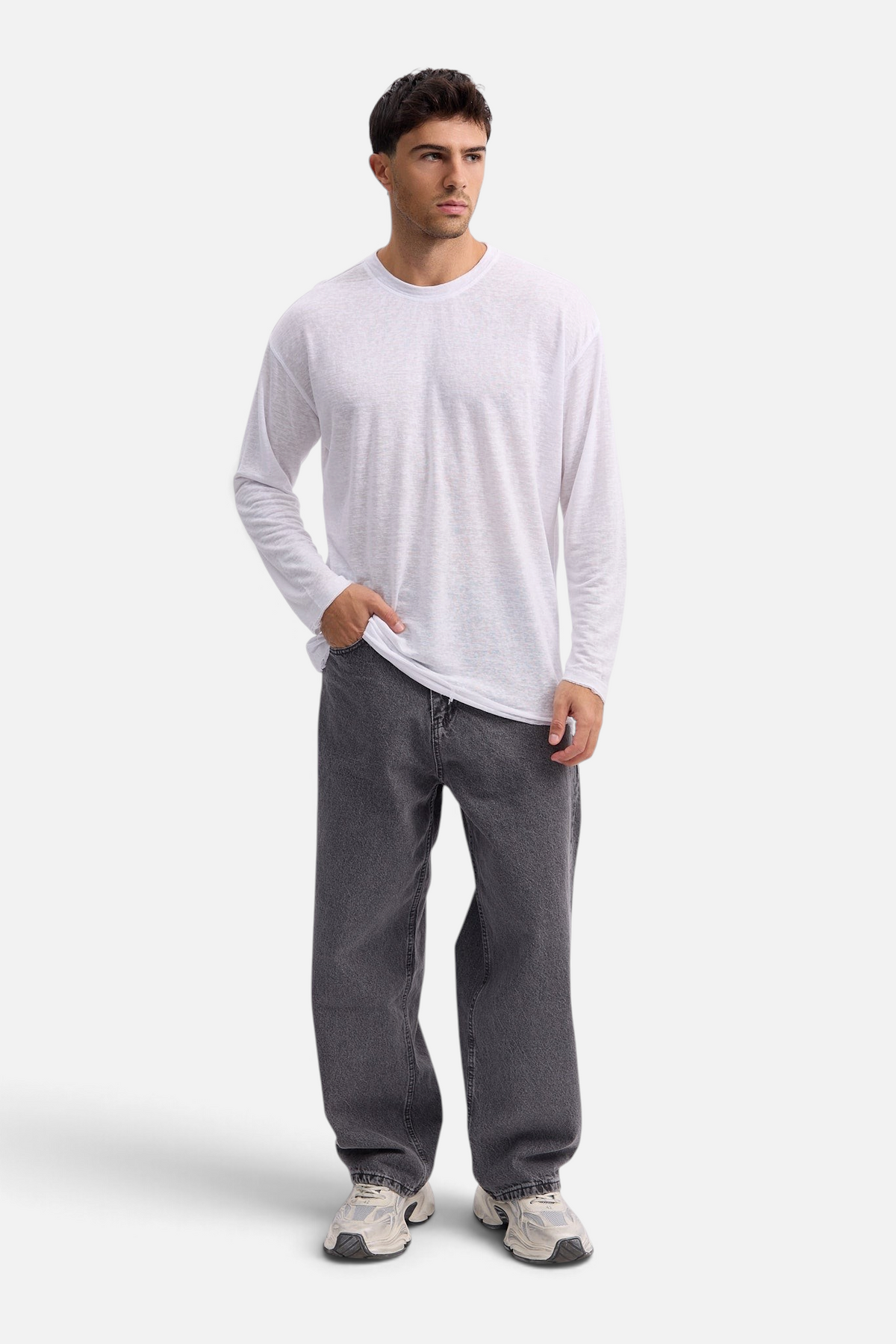 Mainstreamonline white long sleeve linen t-shirt with an oversized fit worn by a male model with grey jeans