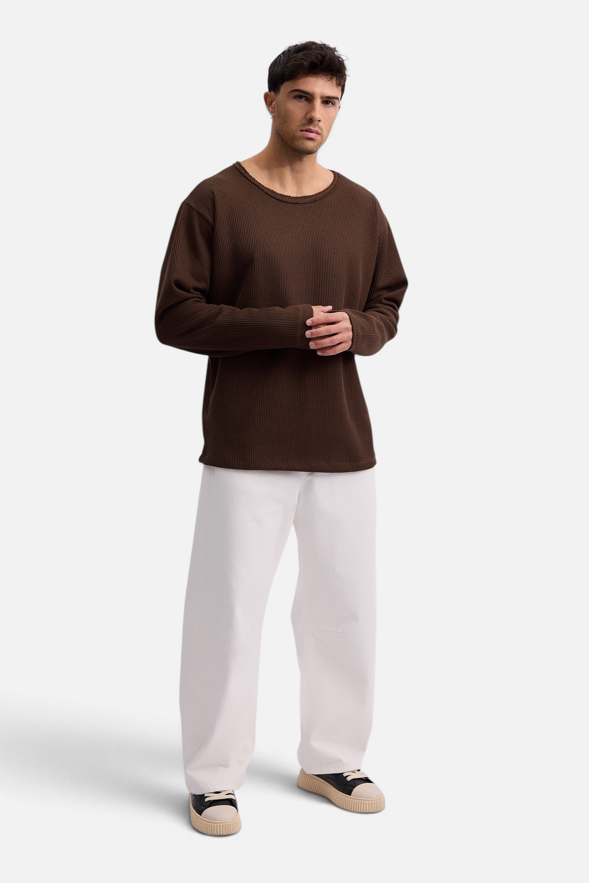 Mainstreamonline Sean Knit oversized brown long-sleeve sweater worn by a male model with white trousers