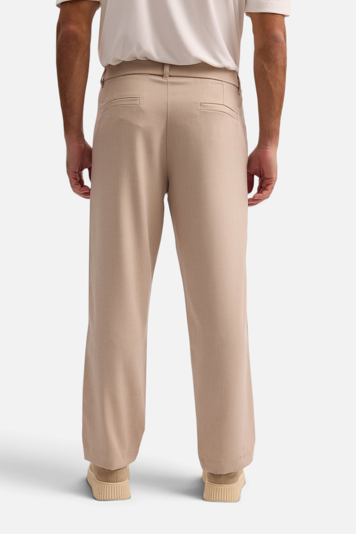 Mainstreamonline beige wide-leg elegant trousers worn by a man, back view showing loose fit and tailored pockets.