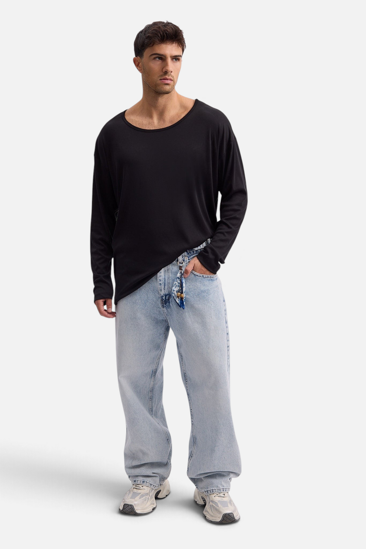 Mainstreamonline model wearing a black long-sleeve oversized Niki T-shirt with a wide scoop neck and light blue jeans