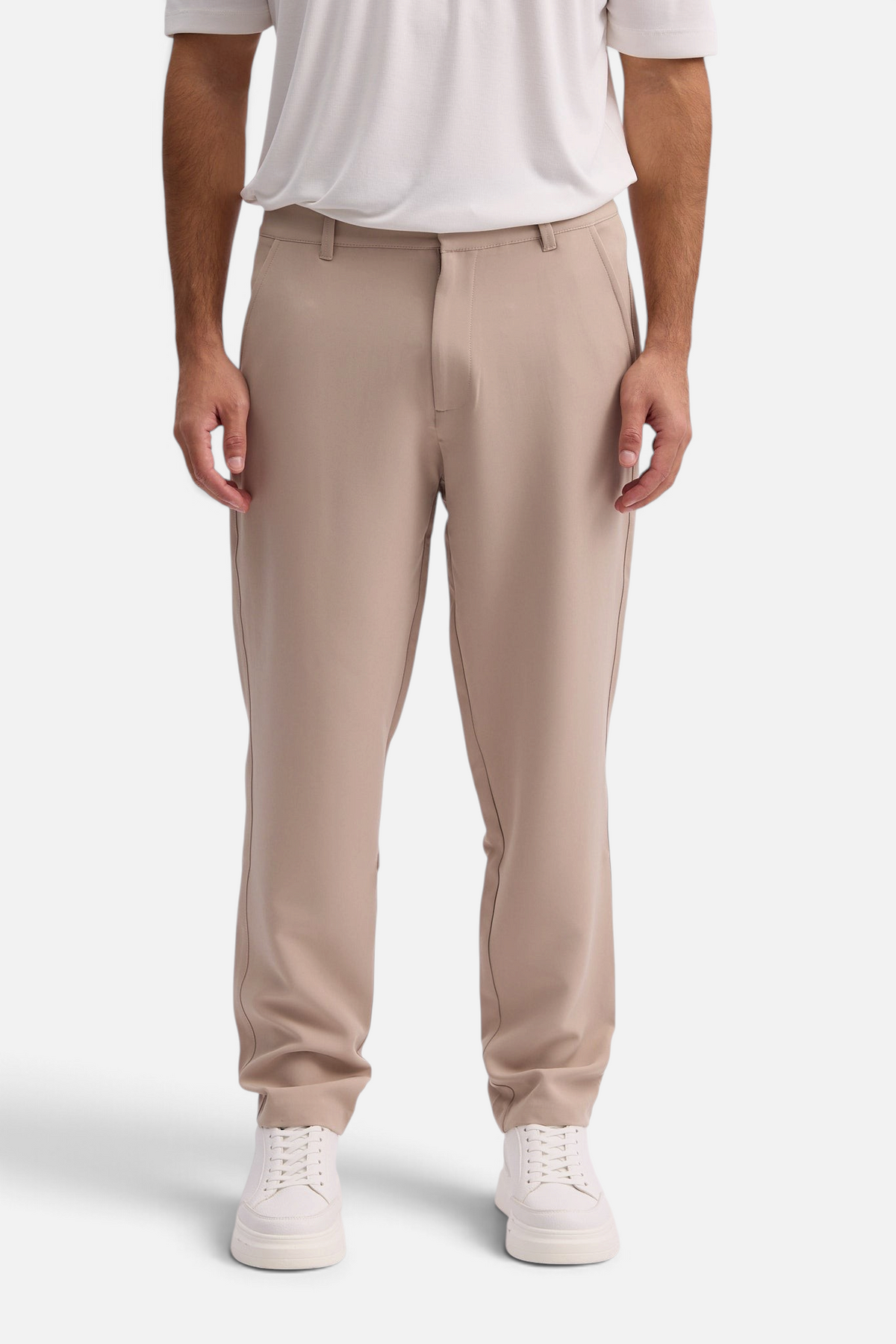 Mainstreamonline Santo Pants in beige with a relaxed wide-leg fit, worn by a man with a white t-shirt and sneakers.