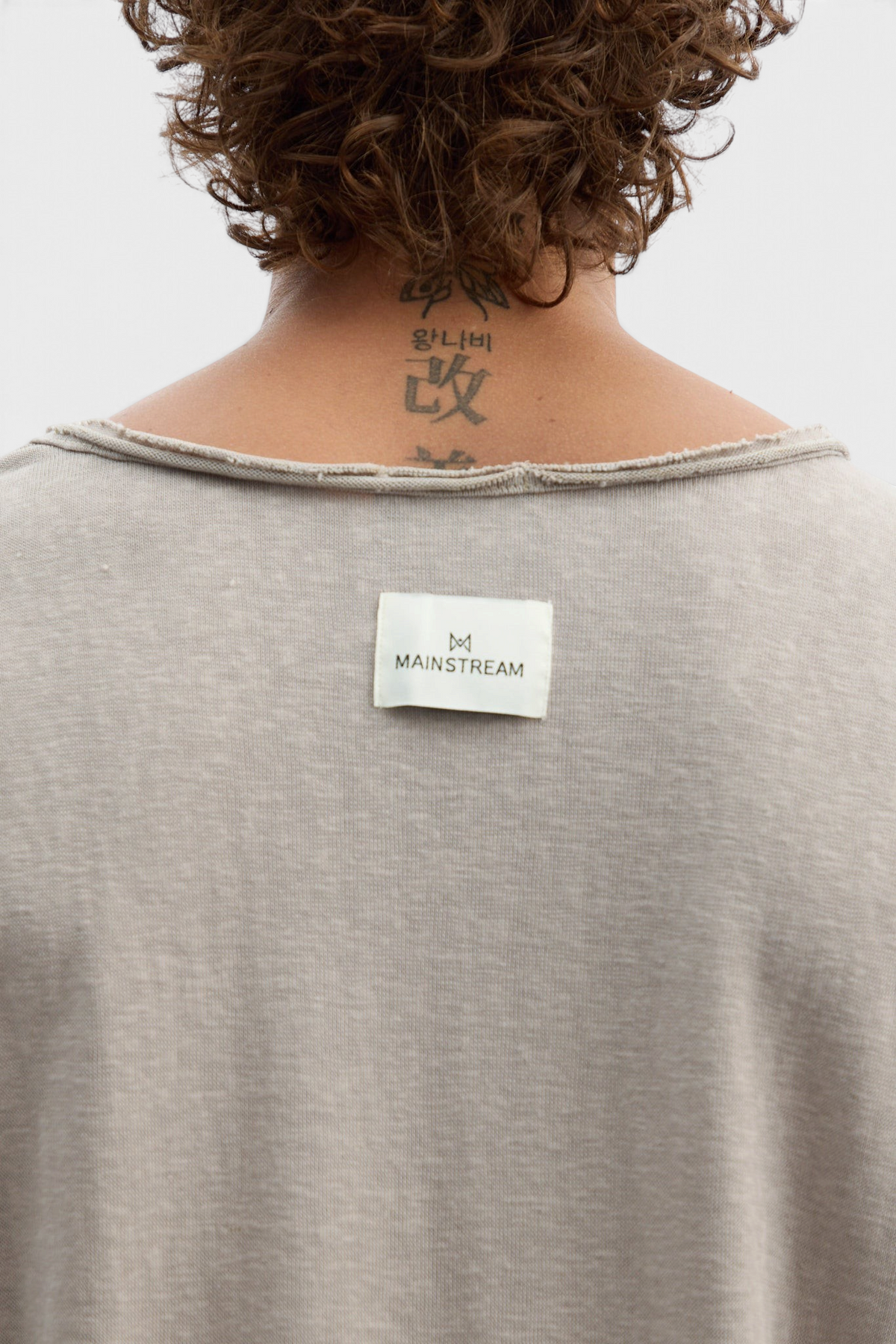 Mainstreamonline beige long sleeve oversized t-shirt with raw edge neckline and branded back label