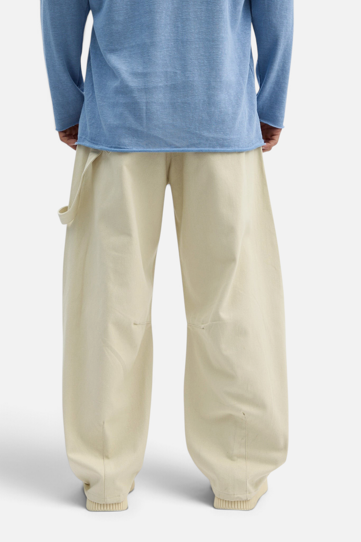 Mainstreamonline beige drill pants with a loose, wide-leg fit worn by a model in a blue long-sleeve shirt