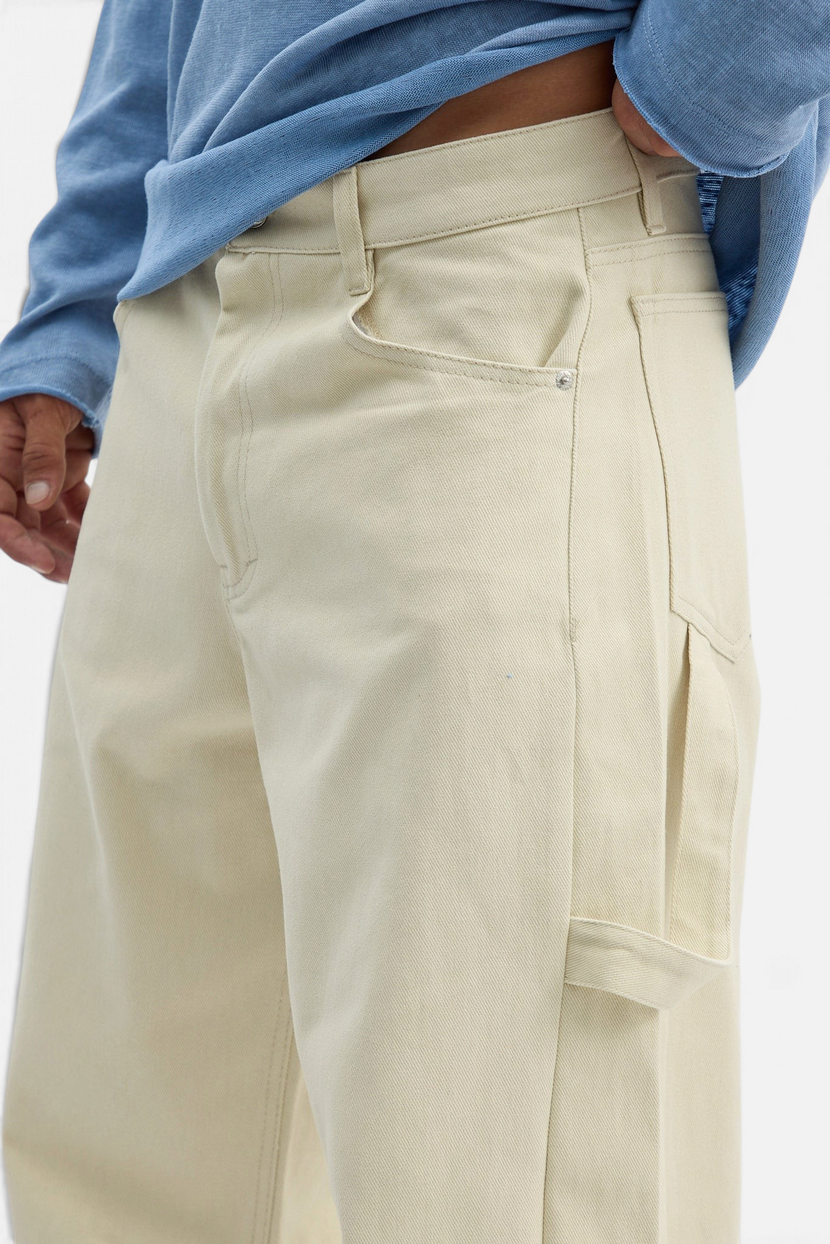 Mainstreamonline beige drill pants with a loose, relaxed fit and utility pocket detail on a model