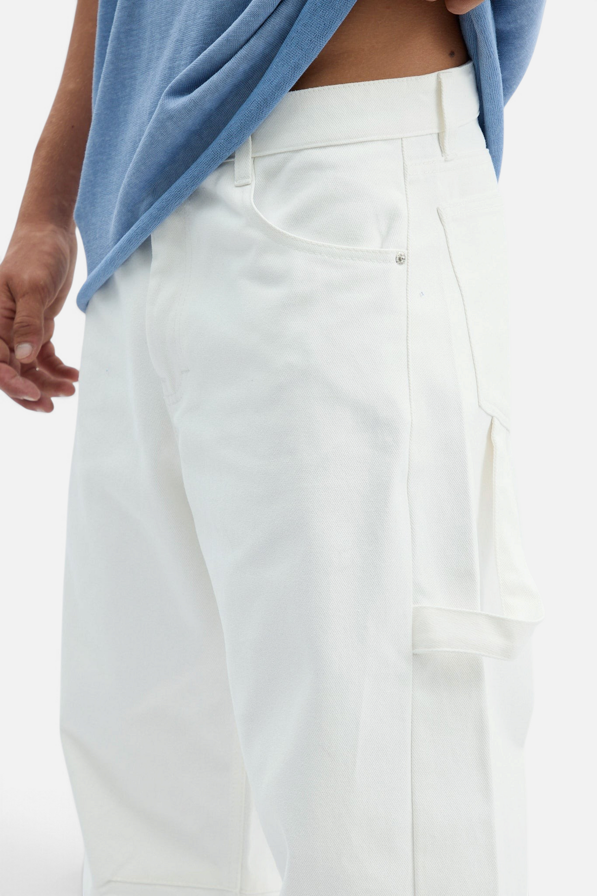 Mainstreamonline white drill pants with a loose, relaxed fit and utility pocket detail on a model