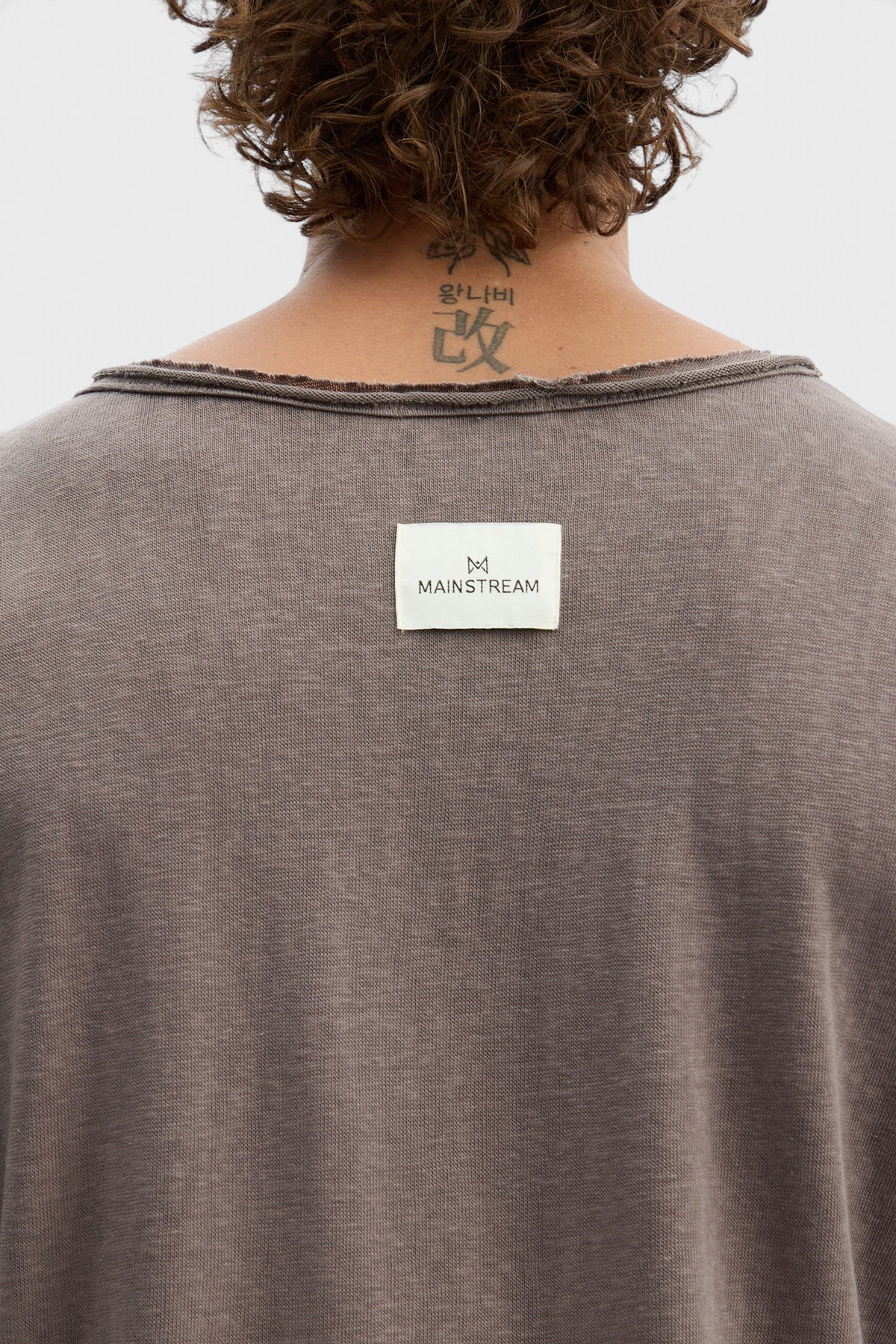 Mainstreamonline brown long sleeve oversized t-shirt with raw edge neckline and branded label on the back