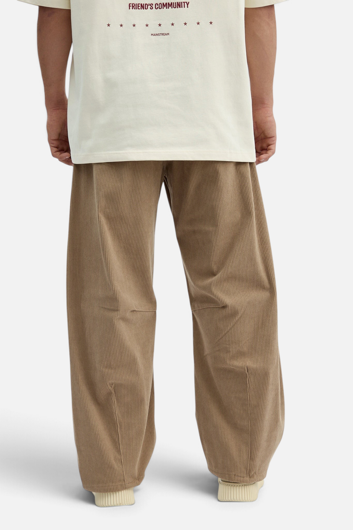 Mainstreamonline brown corduroy baggy pants with a loose, relaxed fit worn by a model from the back view