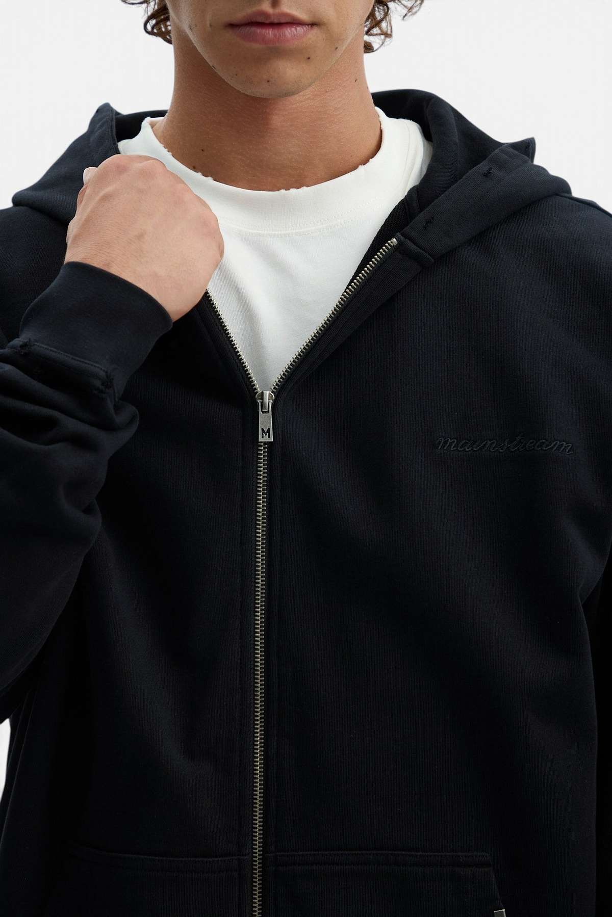 Mainstreamonline Rifts black oversized zip-up hoodie with a clean, relaxed fit worn over a white t-shirt.
