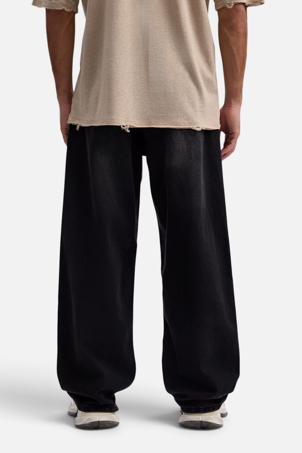 Mainstreamonline baggy skater jeans in black denim with a loose, wide-leg fit worn by a model from the back view